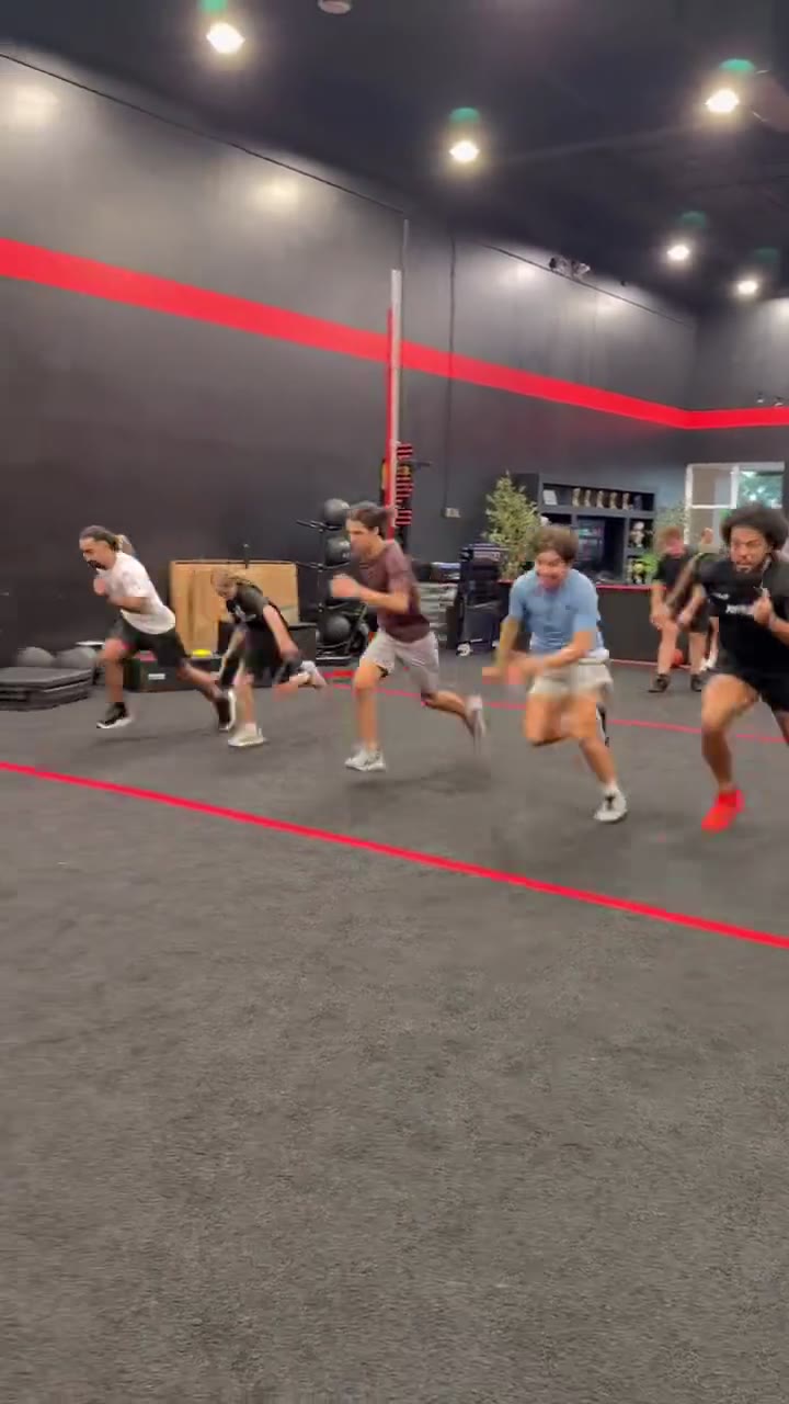 Athletes sprinting down the turf lane at Redline Athletics Fort Myers