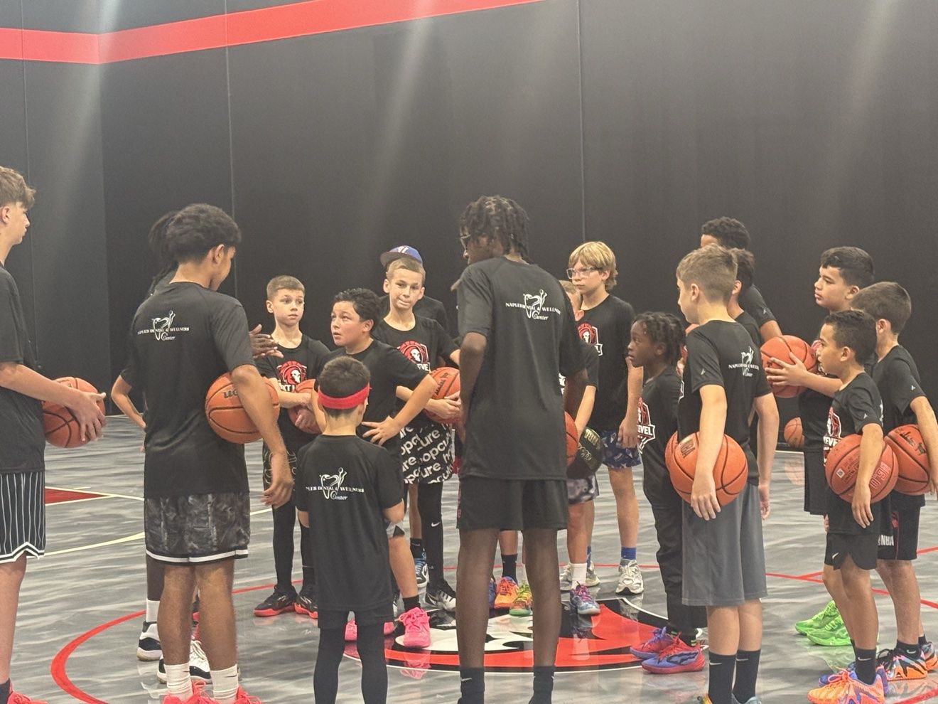 Camp day huddle around a coach on the Next Level court
