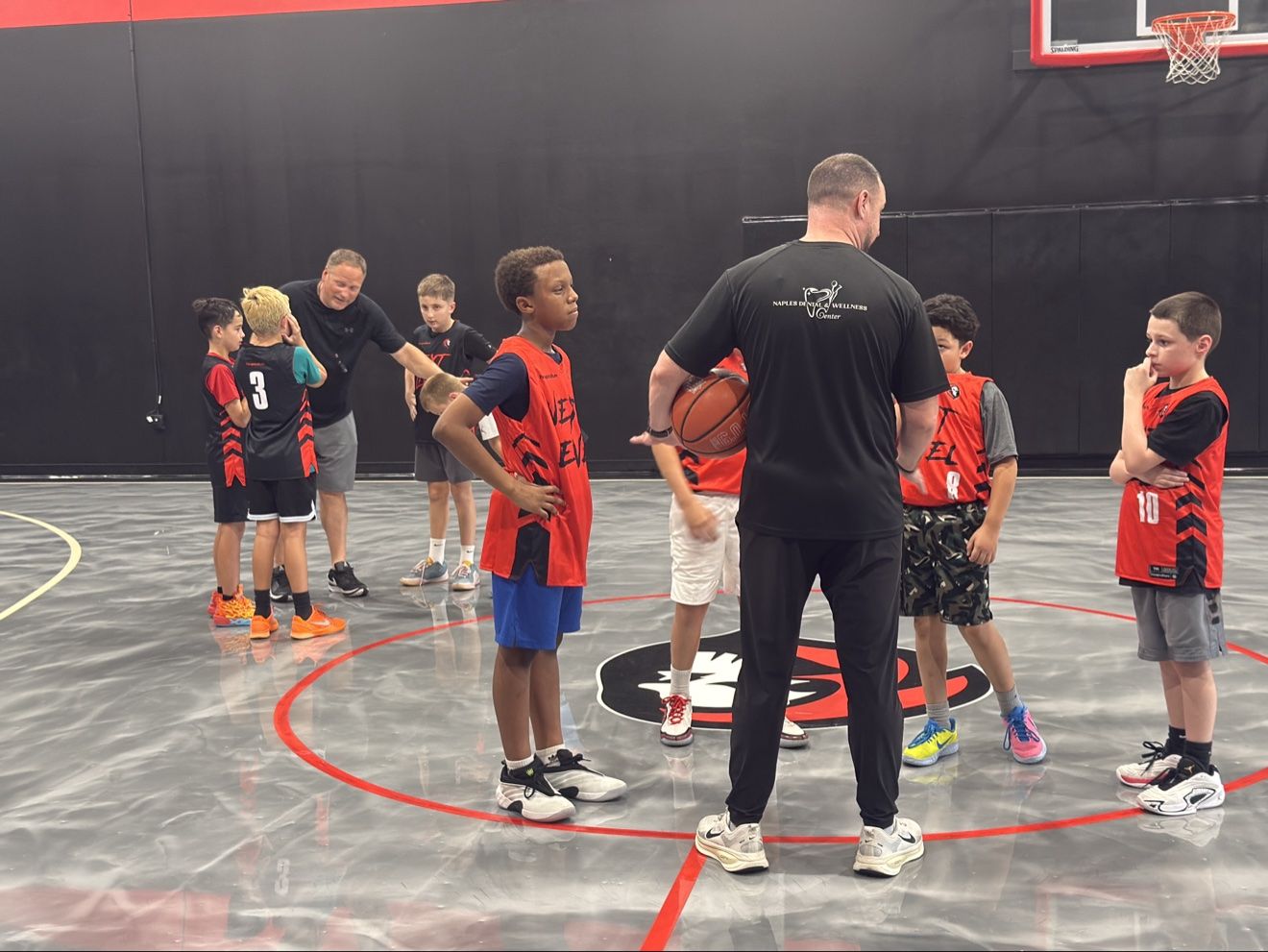 Coach breaking down the next rep with young athletes in a development huddle