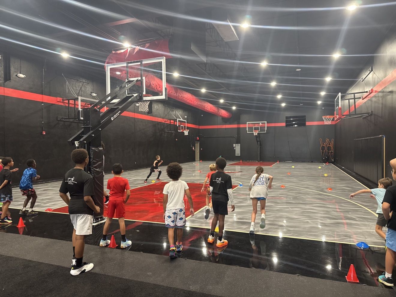 Athletes running cone agility drills across the Next Level court
