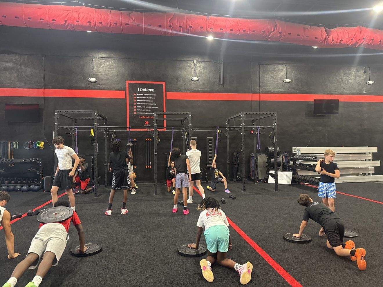 Athletes doing plate push-ups and rack work during a strength session